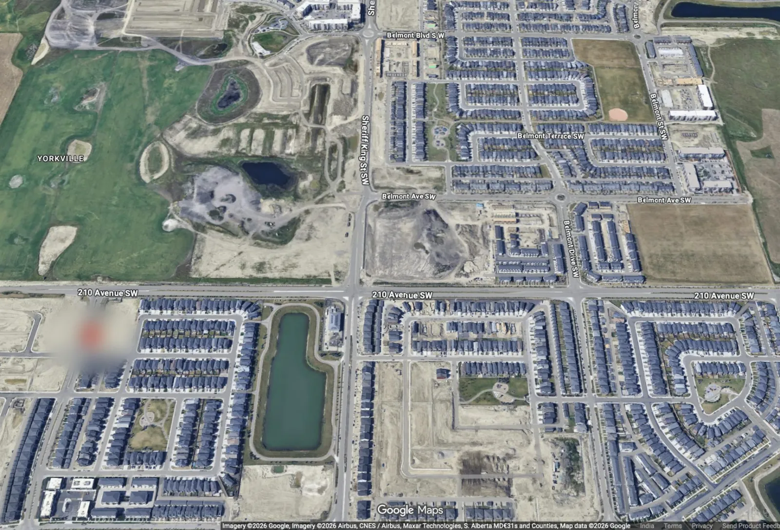 Aerial view of Sirocco and the surrounding SW Calgary communities, with a pond, parks and new streets. The homes’ exact location is softened.